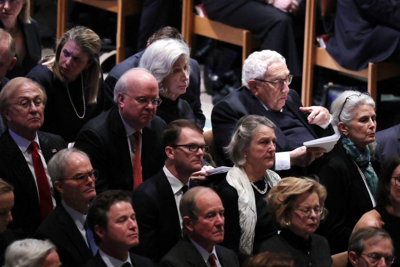Former Secretary of State Henry Kissinger, top right, sits near former White House Chief of Staff Karl Rove at the funeral.