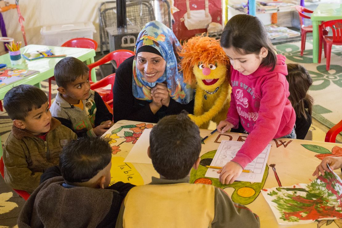 Ameena, a teacher, works with Tonton the muppet during a kindergarten class for Syrian refugee children at the Fneish camp in Lebanon. 