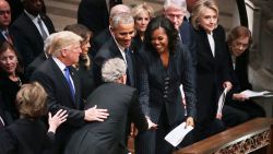 WASHINGTON, DC - DECEMBER 05:  Former U.S. President George W. Bush (C) leans across President Donald Trump and first lady Melania Trump to greet fellow former presidents Barack Obama, Bill Clinton and former first ladies Rosalynn Carter, Hillary Clinton and Michelle Obama during the state funeral for his father and former President George H.W. Bush at the National Cathedral December 05, 2018 in Washington, DC. A WWII combat veteran, Bush served as a member of Congress from Texas, ambassador to the United Nations, director of the CIA, vice president and 41st president of the United States. 