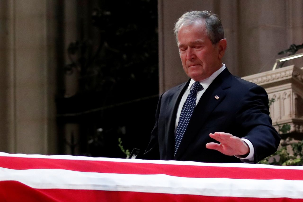 George W. Bush touches his father's casket.