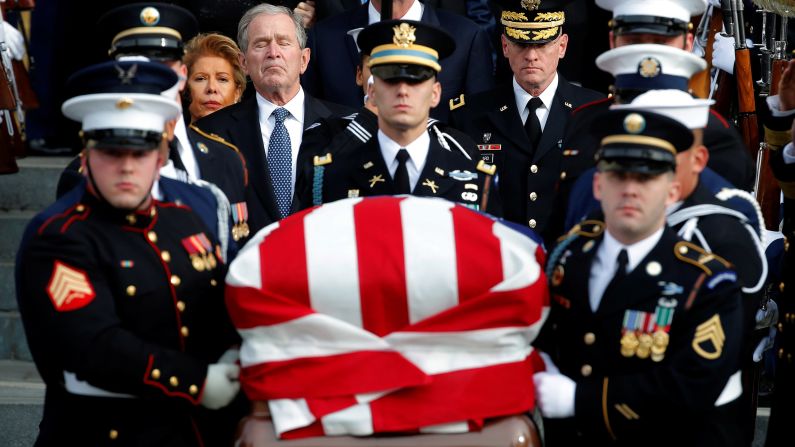 Former President George W. Bush trails a military honor guard carrying his father's casket after a state funeral in Washington on December 5.