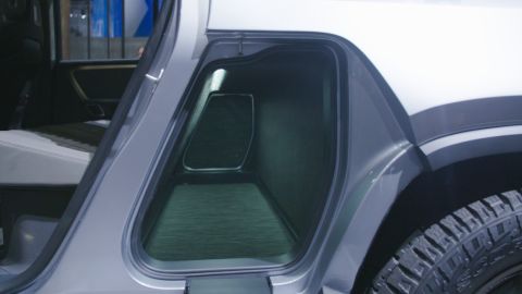 A storage tunnel in the center of the Rivian R1T provides lockable storage space for gear. It has doors that open downward. When opened, they're strong enough to stand on.