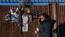 Tilisha Goupall tends a memorial for her younger brother, Jermaine Goupall, at the spot where he was killed by gang members in south London.