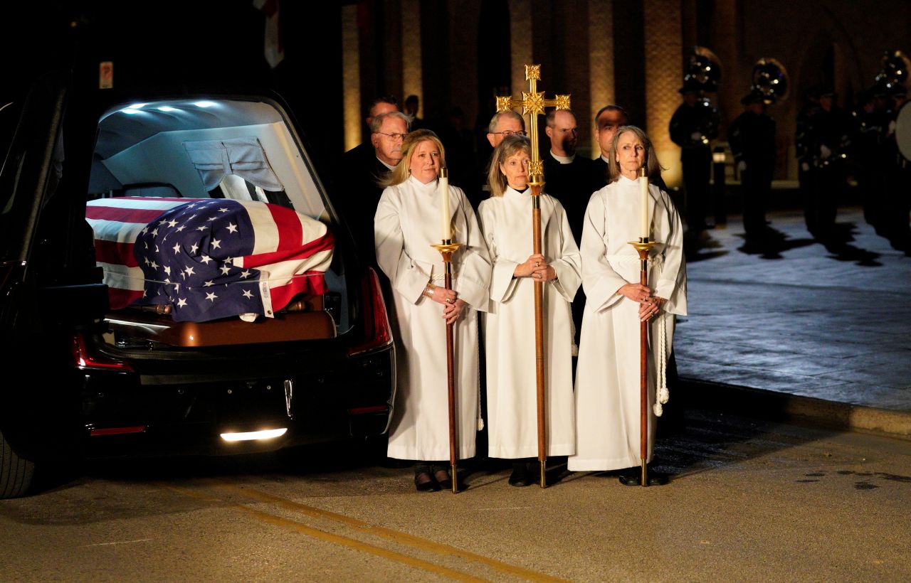 Church members wait next to the hearse during the arrival of Bush's casket on December 5.