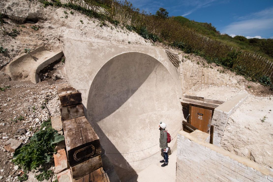 A woman stands by one of the First World War "Sound Mirror" listening devices at the Fan Bay Deep Shelter within the cliffs overlooking Dover, England.