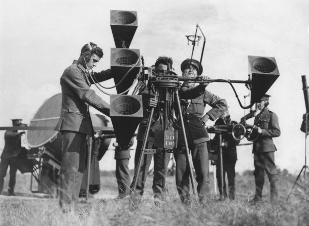 A British military sound locator in use at an airfield in southern England, in 1930. On the left is a searchlight that was used in conjunction with the locator. 