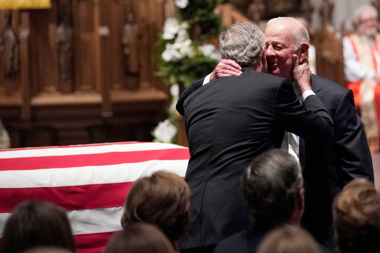 Former President George W. Bush embraces his father's close friend, former Secretary of State James Baker, after giving a eulogy in Houston on December 6.