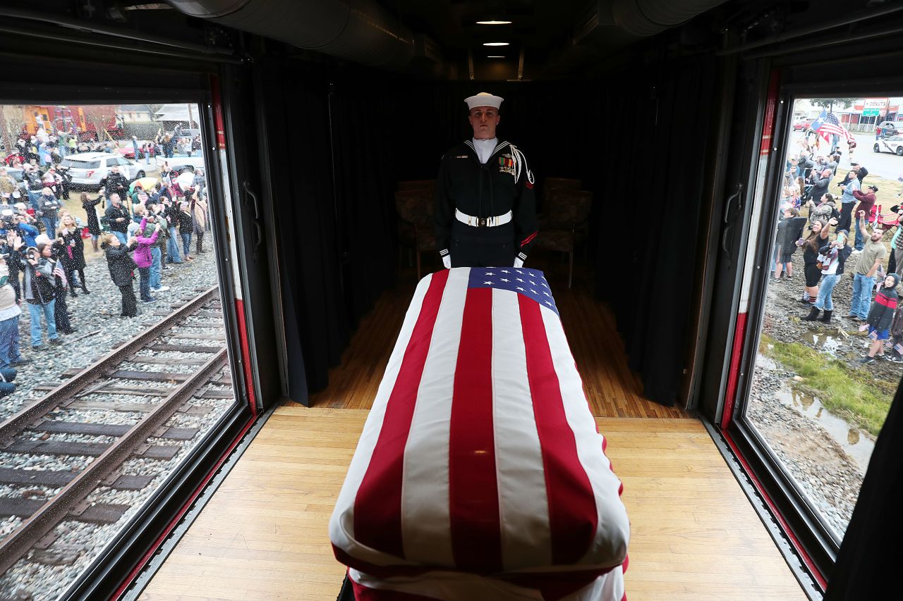 Navy guard Kenneth Knox stands over the flag-draped casket of the late President as a train carries it to his presidential library at Texas A&M University.
