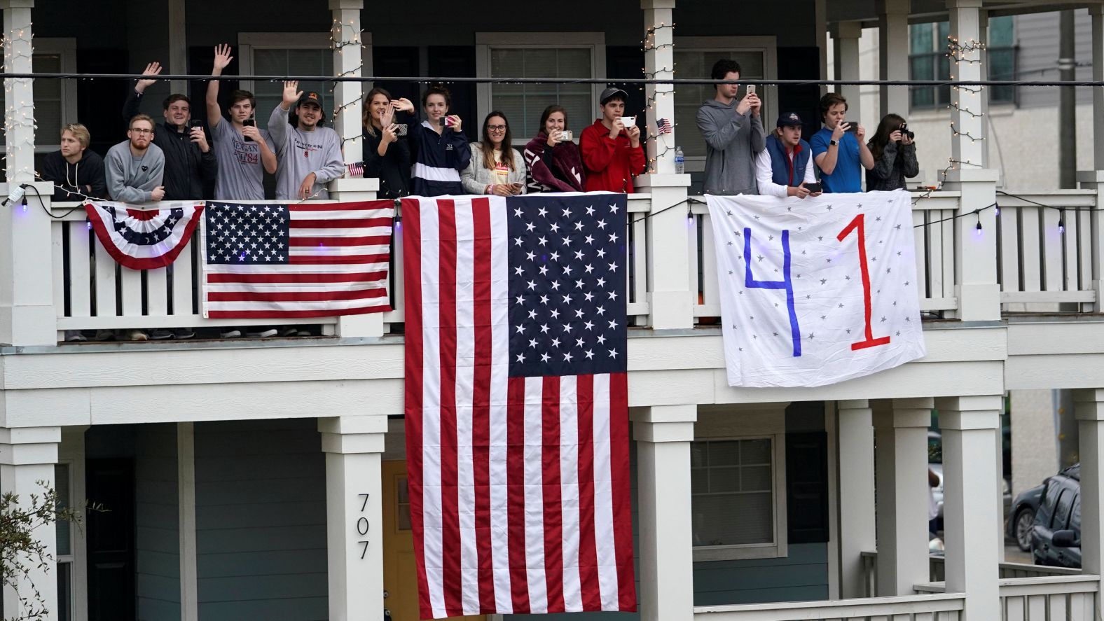 People wave to the train from along the train route.