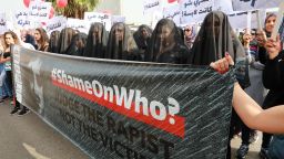 #ShameOnWho activists wearing black veils symbolizing the stigma attached to rape victims. 