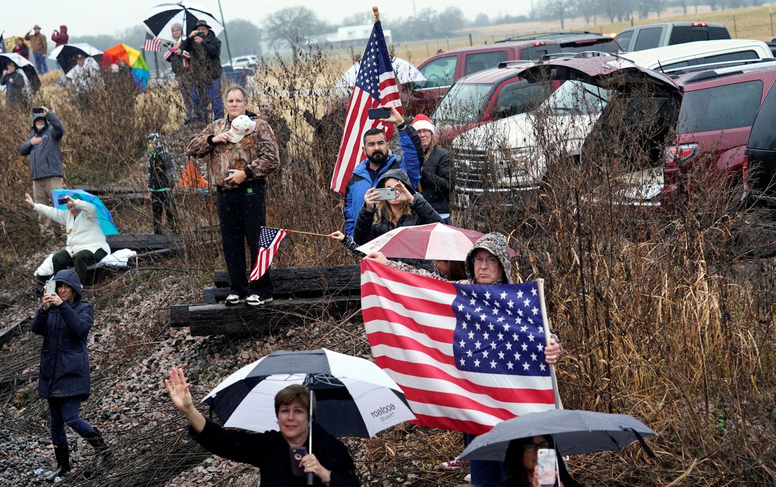 People pay their respects as the train carrying the casket passes Spring, Texas.