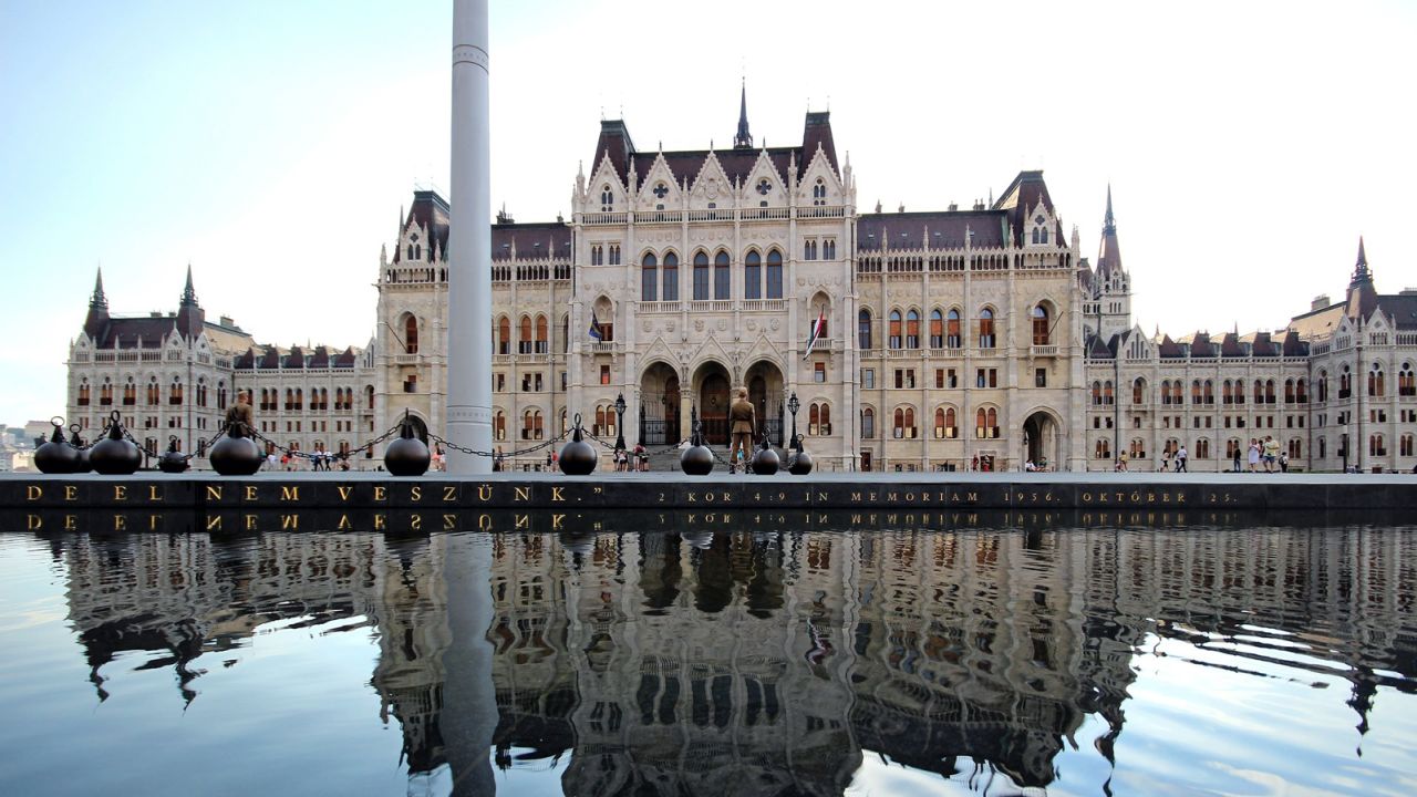 A tribute commemorating the 1956 Hungarian Revolution sits in front of the building.