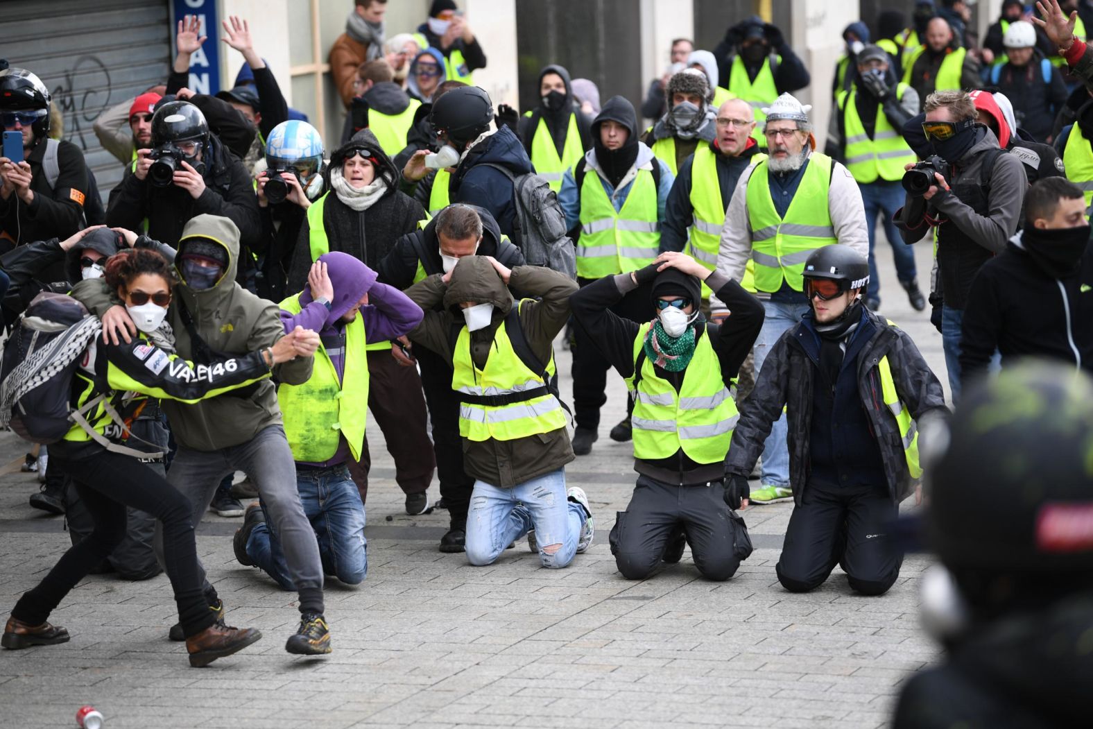 Two demonstrators dance in front a group as they take part on December 8 in the demonstration at the Arc de Triomphe in Paris.