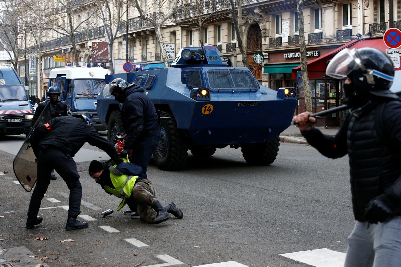French gendarmes apprehend a protester on December 8 in Paris.