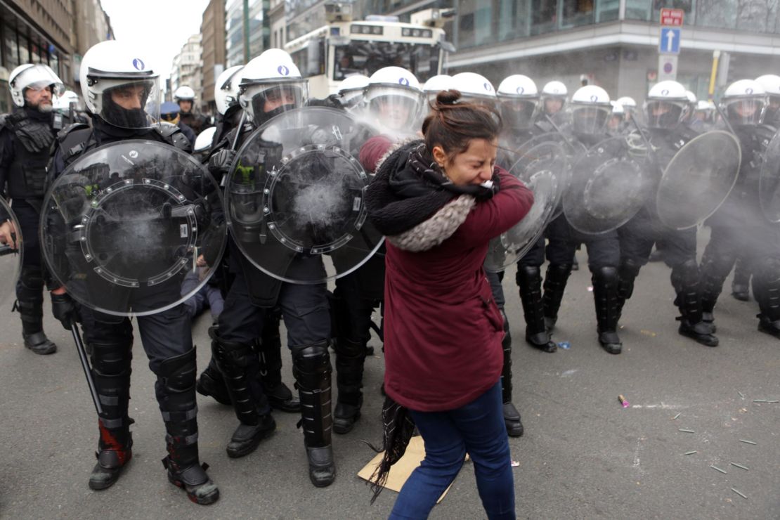 Riot police forces spray tear gas at a woman during copycat protests Saturday in Brussels, Belgium.
