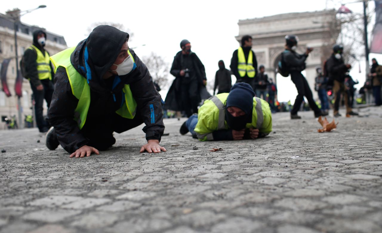 Demonstrators drop flat to the ground on the Champs-Elysees avenue during a protest on Saturday, December 8, in Paris. 