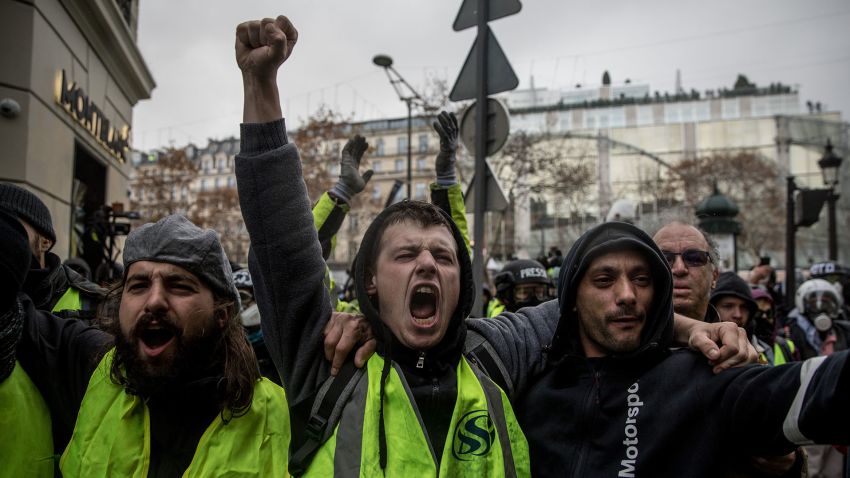 PARIS, FRANCE - DECEMBER 08: Protesters chant slogans as during the 'yellow vests' demonstration on the Champs-Elysées near the Arc de Triomphe on December 8, 2018 in Paris France. ''Yellow Vests' ('Gilet Jaunes' or 'Vestes Jaunes') is a protest movement without political affiliation which was inspired by opposition to a new fuel tax. After a month of protests, which have wrecked parts of Paris and other French cities, there are fears the movement has been infiltrated by 'ultra-violent' protesters. Today's protest has involved at least 5,000 demonstrators gathering in the Parisian city centre with police having made over 200 arrests so far.  (Photo by Chris McGrath/Getty Images)