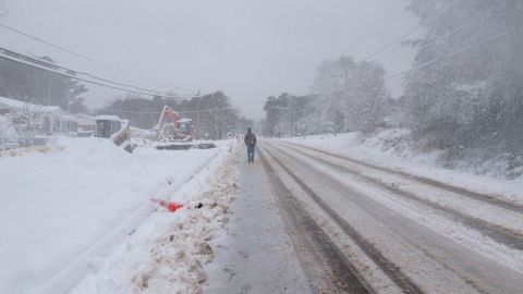 A man tries to walk through blowing snow Sunday in Wake Forest, North Carolina.