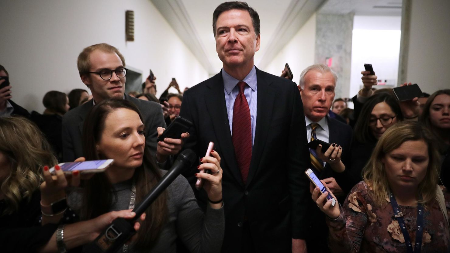 Former Federal Bureau of Investigation Director James Comey is surrounded by reporters after testifying to the House Judiciary and Oversight and Government Reform committees at the Rayburn House Office Building on Capitol Hill December 7, 2018, in Washington, DC. 