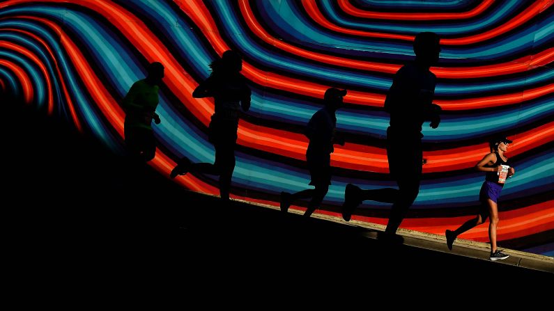 Runners pass by a mural during Humana Rock 'n' Roll San Antonio Marathon on Saturday, December 1 in San Antonio, Texas.