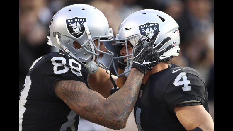 Marcell Ateman and Derek Carr of the Oakland Raiders celebrate after connecting on a touchdown pass against the Kansas City Chiefs during the second half of an NFL football game in Oakland, California on Sunday, December 2.