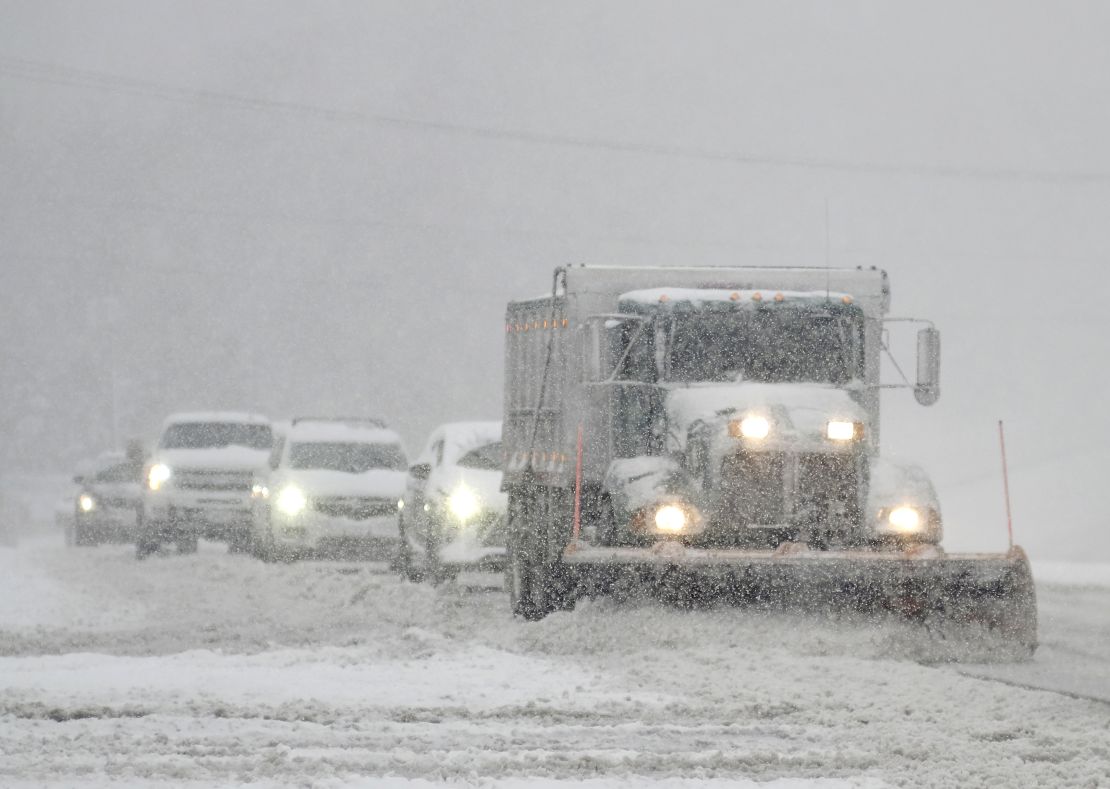 A snowplow is followed closely by cars as it clears US 301 in Hanover County, Virginia, on Sunday.