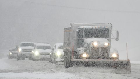 A snowplow is followed closely by cars as it clears US 301 in Hanover County, Virginia, on Sunday.