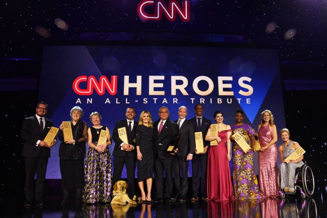 The Top 10 CNN Heroes of 2018 pose with Anderson Cooper and Kelly Ripa onstage.