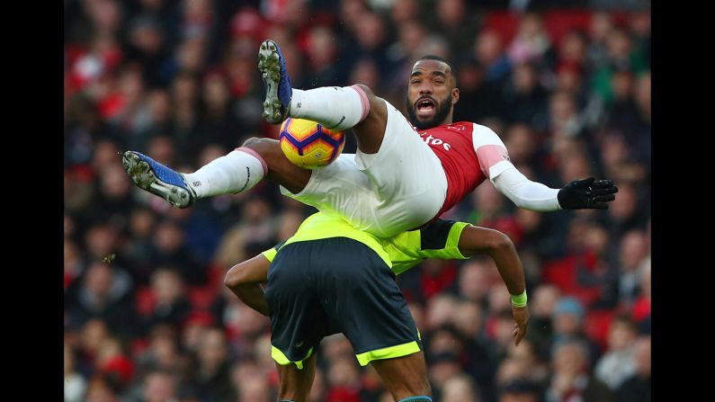 Arsenal's Alexandre Lacazette is challenged by Huddersfield Town's Mathias Jorgensen on Saturday, December 8 in London.