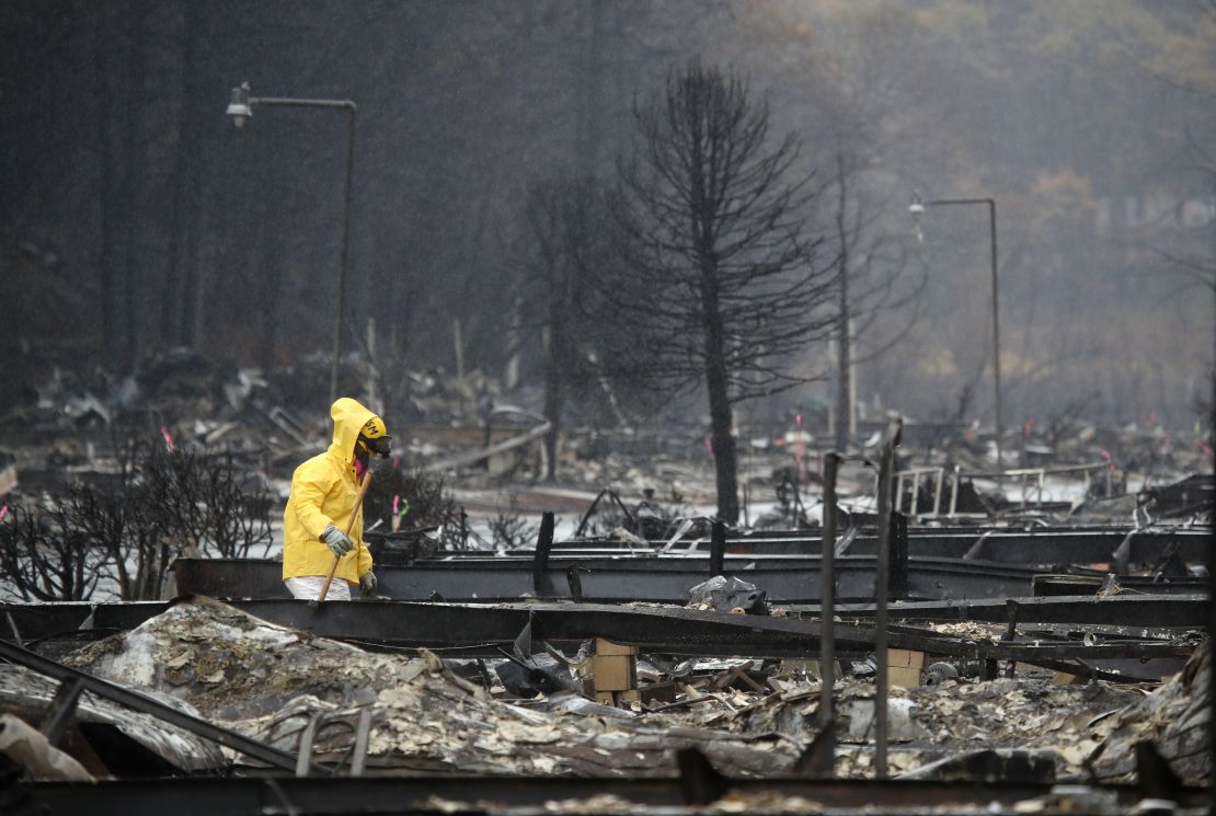 A search and rescue crew member looks through the ruins of a mobile home park in Paradise.