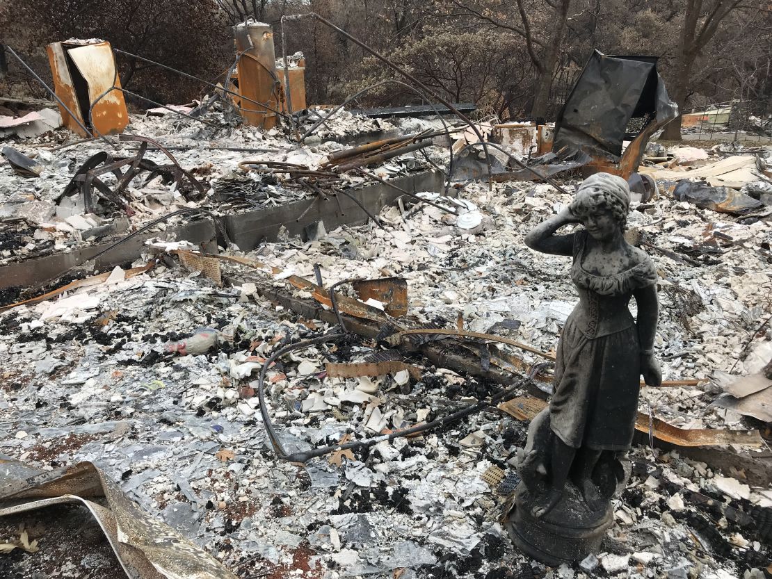 A statue stands amid the ruins of a home destroyed by the Camp Fire in Paradise, California.