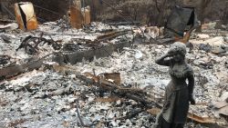 A statue stands amid the ruins of a home destroyed by the Camp Fire in Paradise, California.