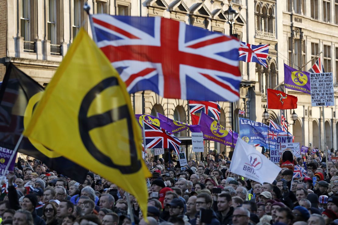 Protesters hold up placards and Union flags as they attend a pro-Brexit rally promoted by UKIP in central London on December 9, 2018.