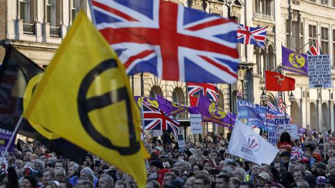 Protesters hold up placards and Union flags as they attend a pro-Brexit rally promoted by UKIP in central London on December 9, 2018.