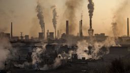 INNER MONGOLIA, CHINA - NOVEMBER 04: Smoke billows from a large steel plant as a Chinese labourer works at an unauthorized steel factory, foreground, on November 4, 2016 in Inner Mongolia, China. To meet China's targets to slash emissions of carbon dioxide, authorities are pushing to shut down privately owned steel, coal, and other high-polluting factories scattered across rural areas. In many cases, factory owners say they pay informal 'fines' to local inspectors and then re-open. The enforcement comes as the future of U.S. support for the 2015 Paris Agreement is in question, leaving China poised as an unlikely leader in the international effort against climate change. U.S. president-elect Donald Trump has sent mixed signals about whether he will withdraw the U.S. from commitments to curb greenhouse gases that, according to scientists, are causing the earth's temperature to rise. Trump once declared that the concept of global warming was "created" by China in order to hurt U.S. manufacturing. ChinaÍs leadership has stated that any change in U.S. climate policy will not affect its commitment to implement the climate action plan. While the world's biggest polluter, China is also a global leader in establishing renewable energy sources such as wind and solar power. (Photo by Kevin Frayer/Getty Images)
