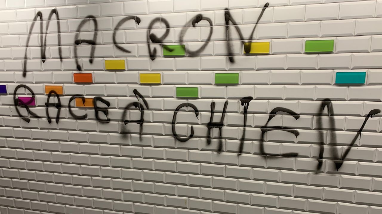 Graffiti on the streets of Paris reads: 'Macron, breed of dog.'