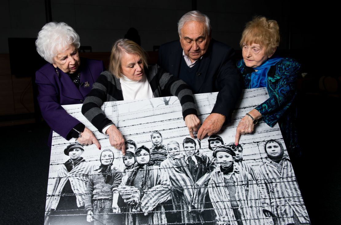 Far right: Eva Kor in 2015 points at an image of herself as a child taken during the liberation of Auschwitz, along with other survivors. 
