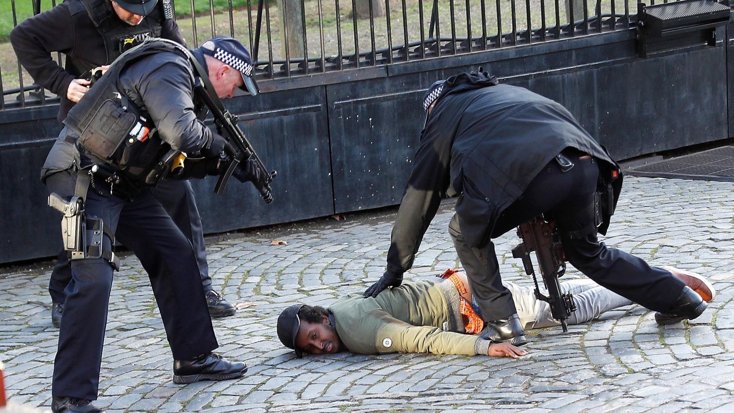 Armed police restrain a man inside the grounds of the Houses of Parliament on Tuesday.