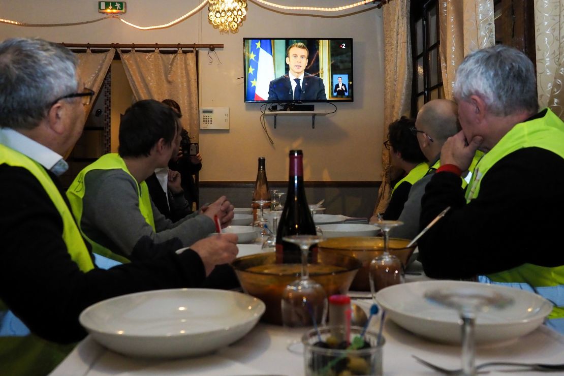 Yellow vest protesters watch Macron's address to the nation on Monday night. 