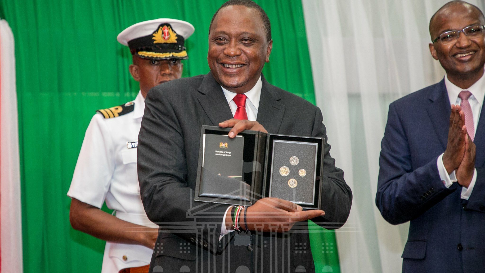 Kenya's President Uhuru Kenyatta unveils the county's new currency coins in Nairobi's capital on December 11, 2018.