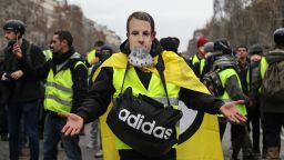 A protestor wearing a "yellow vest" (gilet jaune) and with a French President Emmanuel Macron mask poses on the Champs Elysees avenue in Paris on December 8, 2018 during protest against rising costs of living they blame on high taxes. - Paris was on high alert on December 8 with major security measures in place ahead of fresh "yellow vest" protests which authorities fear could turn violent for a second weekend in a row. (Photo by Zakaria ABDELKAFI / AFP)        (Photo credit should read ZAKARIA ABDELKAFI/AFP/Getty Images)