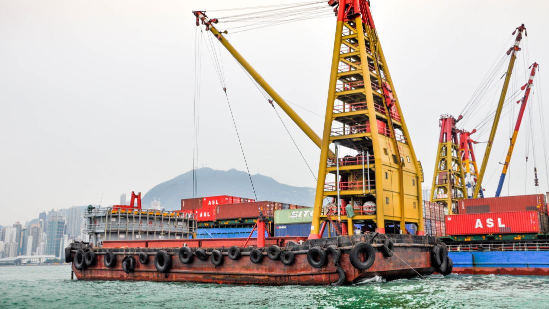 <strong>Unloading the cargo: </strong>Some of the work of Hong Kong's container port is done well out into the harbor, where barges unload and load smaller container vessels. 