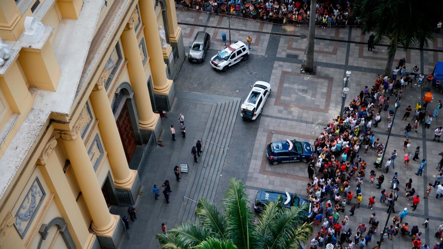 People gather outside the Cathedral of Campina after a man opened fire during mass and killed at least four people before committing suicide on Tuesday.
