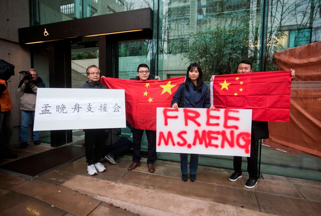 Supporters hold signs and Chinese flags outside court in Canada during the third day of a bail hearing for Meng Wanzhou, the chief financial officer of Huawei.