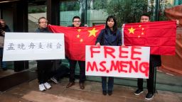 Supporters hold signs and Chinese flags outside British Columbia Supreme Court during the third day of a bail hearing for Meng Wanzhou, the chief financial officer of Huawei Technologies, in Vancouver, on Tuesday December 11, 2018.  (Darryl Dyck/The Canadian Press via AP)