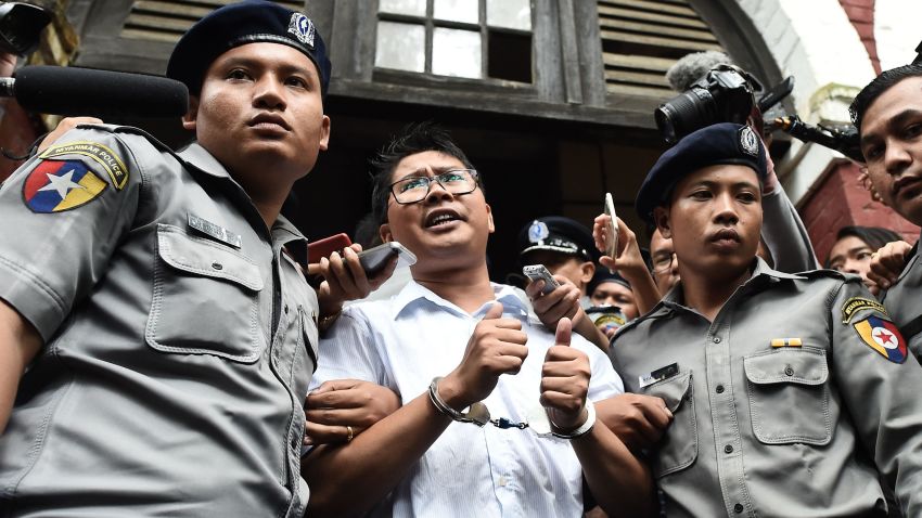 TOPSHOT - Myanmar journalist Wa Lone (C) is escorted by police after being sentenced by a court to jail in Yangon on September 3, 2018. - Two Reuters journalists were jailed on September 3 for seven years for breaching Myanmar's official secrets act during their reporting of the Rohingya crisis, a judge said, a case that has drawn outrage as an attack on media freedom. (Photo by Ye Aung THU / AFP)        (Photo credit should read YE AUNG THU/AFP/Getty Images)