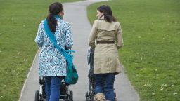 women pushing strollers stock