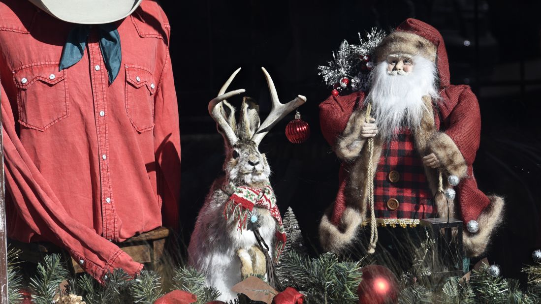 <strong>United States:</strong>  In Santa Fe, New Mexico, a window display features an antique Santa Claus doll, Western shirt and a "jackalope," a mythical animal of North American folklore described as a jackrabbit with antelope horns.