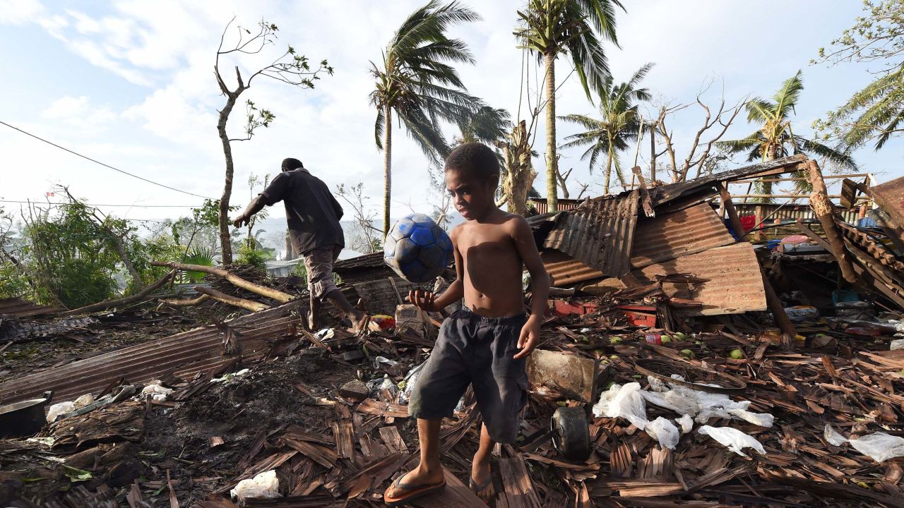 A boy walks through through the ruins of his family home with his father Phillip in 2015 in Port Vila, Vanuatu after Cyclone Pam.