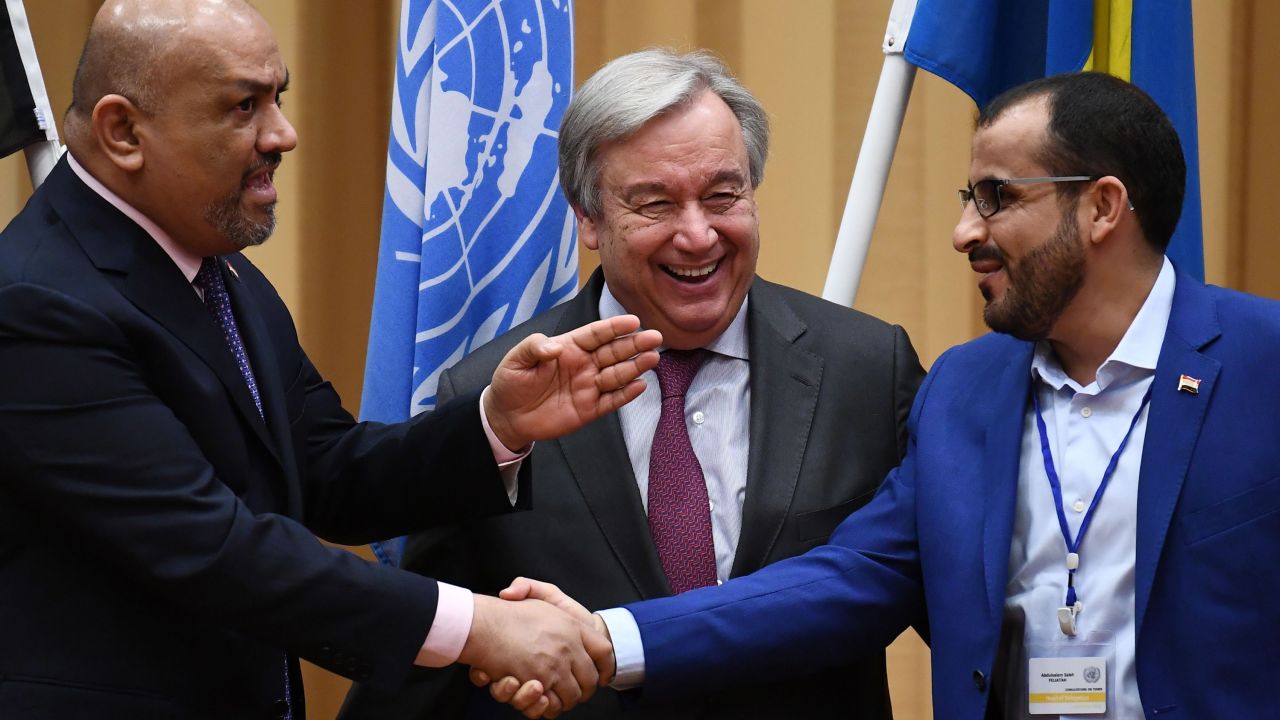 Yemen's Khaled al-Yamani, left, and rebel negotiator Mohammed Abdelsalam shake hands Thursday under the watch of UN chief Antonio Guterres.